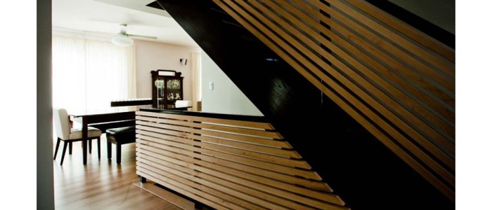 modern stair rail in horizontal wood slats in maple, stringers painted black, walls light tan