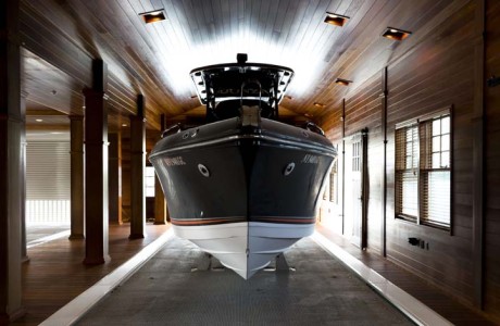 Boat lifted up in boathouse slip. walls, floors, vaulted ceiling all in natural cedar