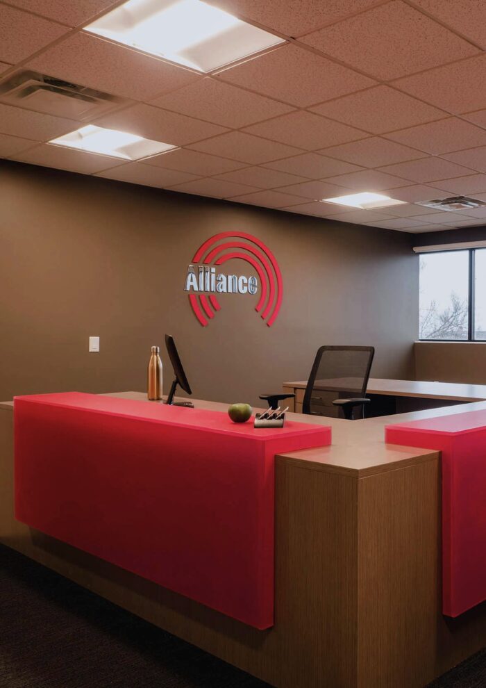 Reception area featuring Alliance Security Team's brand colors and curved desk design.