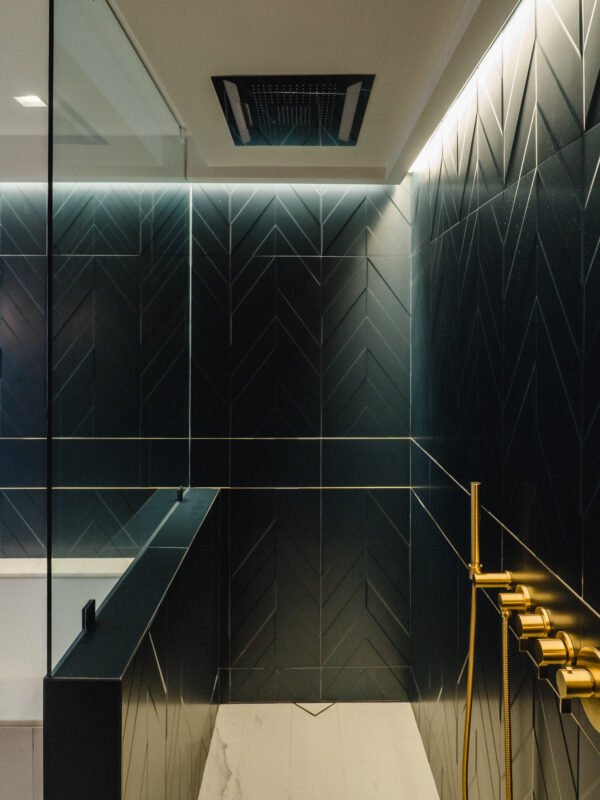 Deep navy blue herringbone tile with brass accents