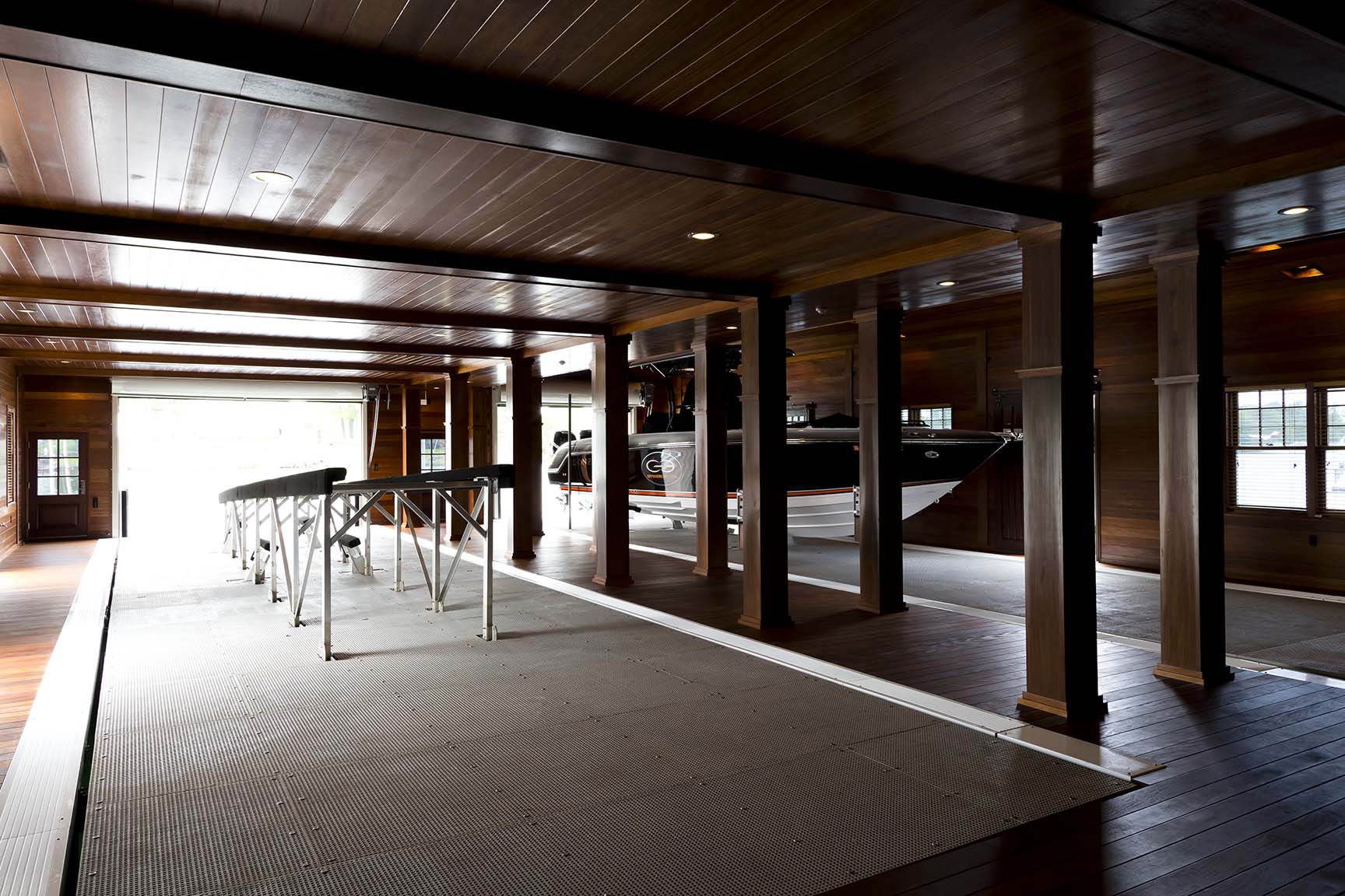 Island boathouse with natural wood siding and large entertaining deck