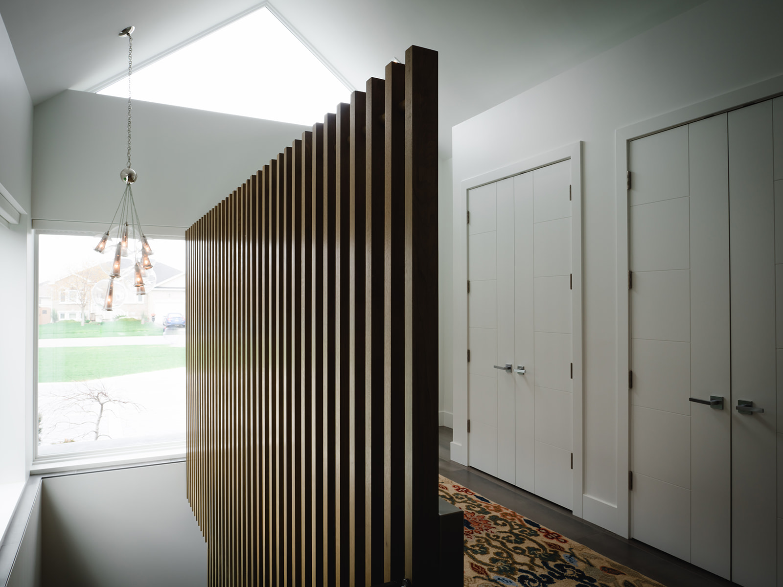 bright foyer entry with custom partition detail in oak