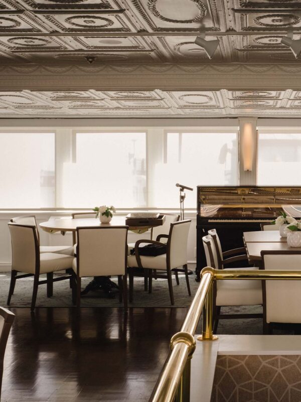 Formal dining area with brass railings and classic tin ceiling panels aboard historic river cruise ship