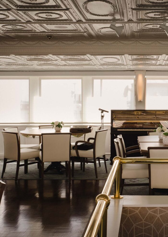 Formal dining area with brass railings and classic tin ceiling panels aboard historic river cruise ship