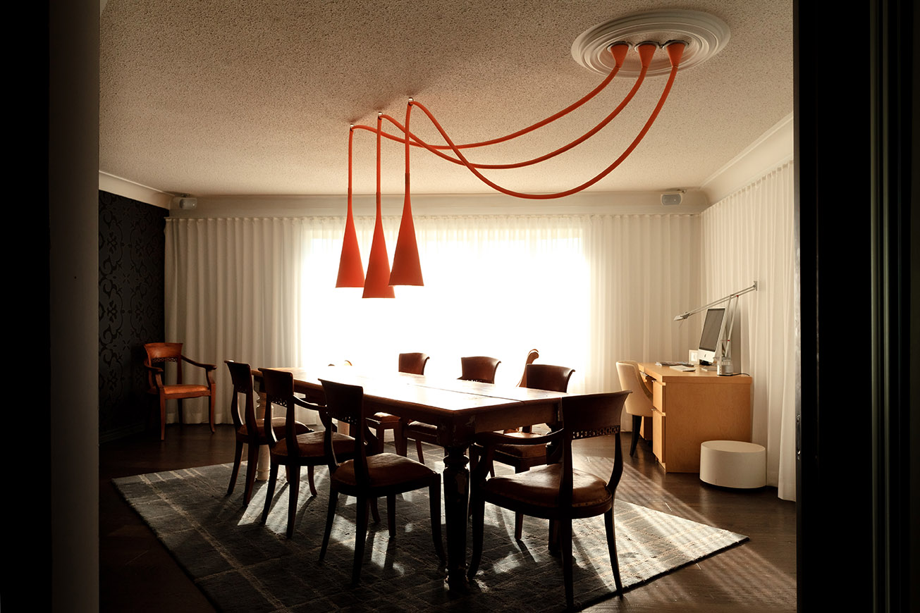Dining room with traditional furniture and bold orange pendant light cluster