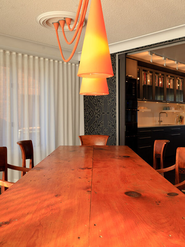 Traditional dining table paired with contemporary orange pendant lights