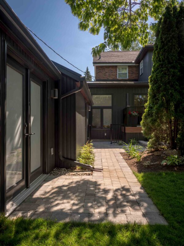 Side yard walkway with paver stones and black exterior wall details