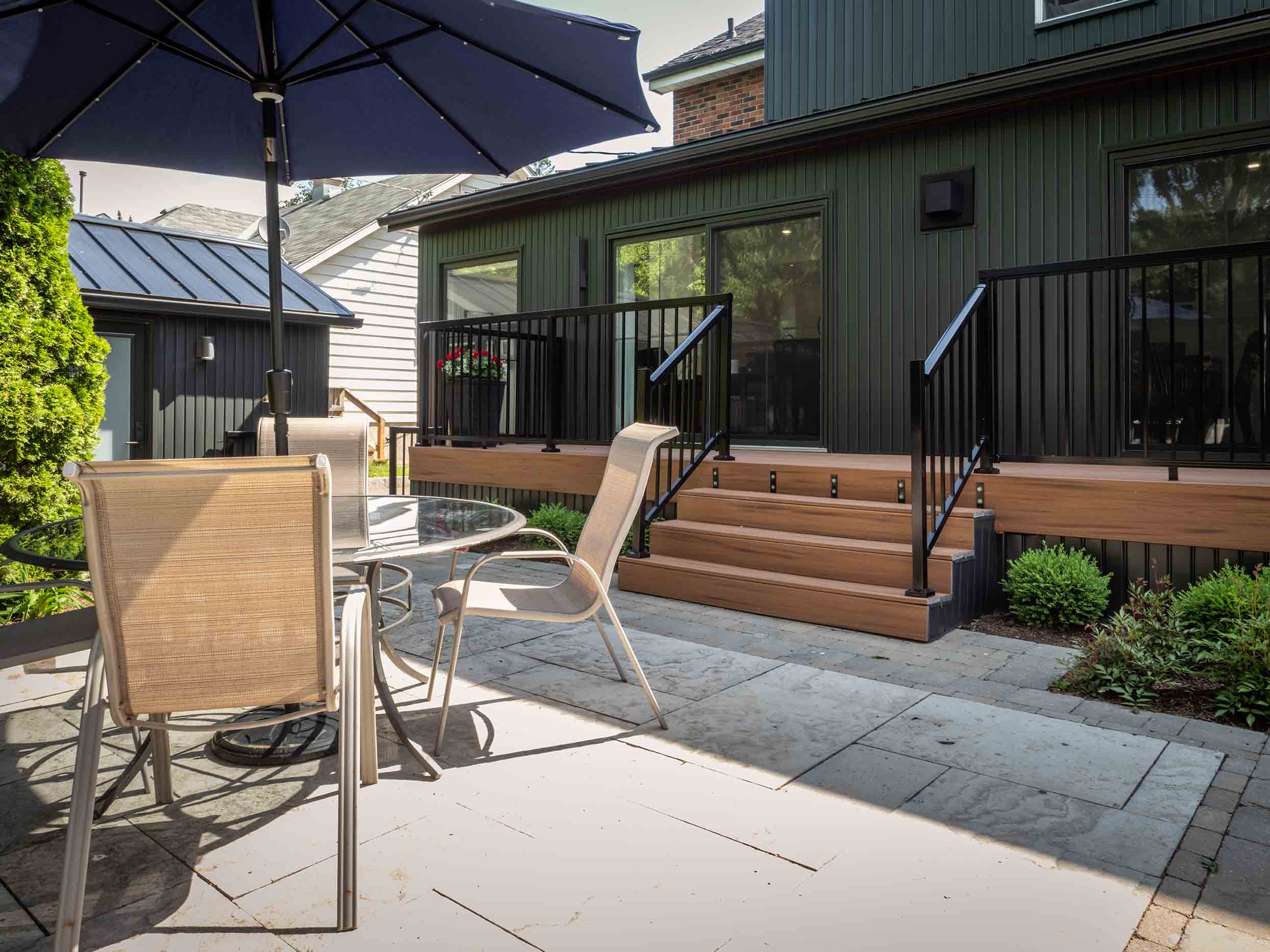 View of rear yard showing black addition, modern deck.
