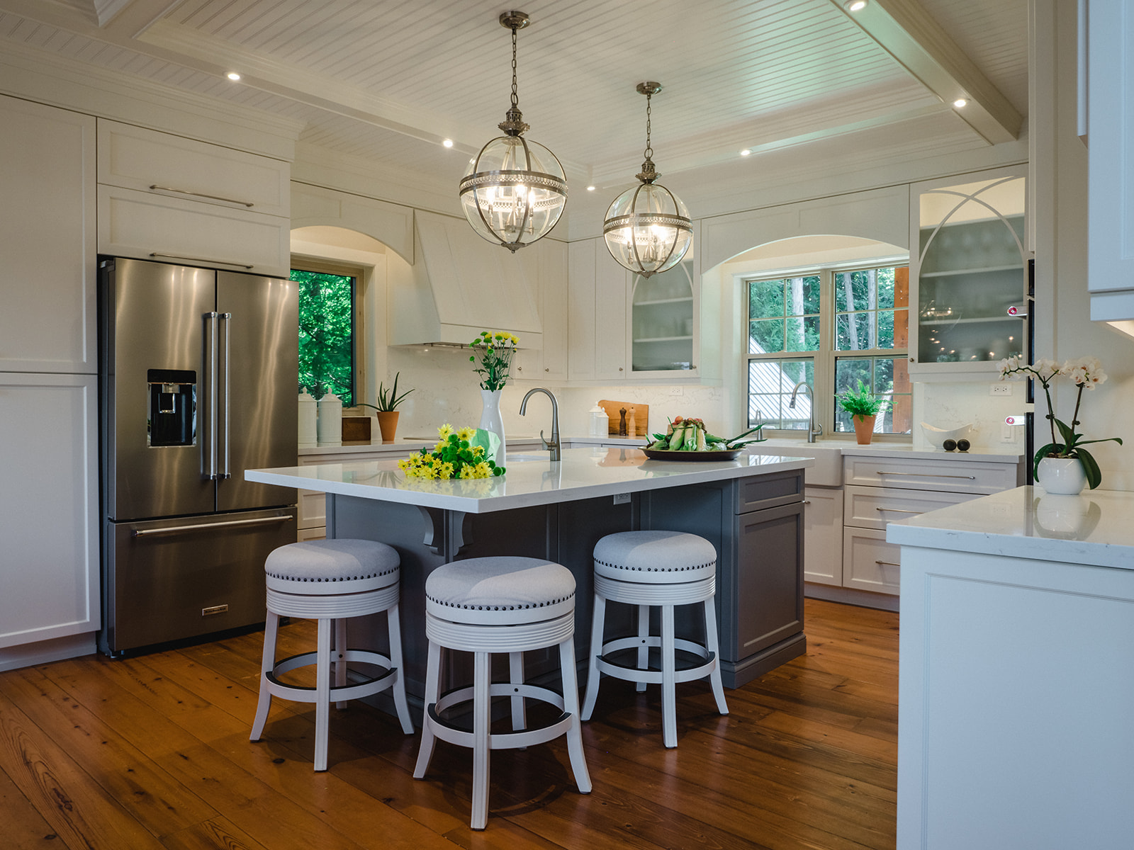 Cottage kitchen with white cabinetry and custom millwork hood