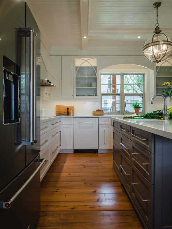 Cabinetry featuring glass-front doors, undercabinet lighting, and a decorative range hood.
